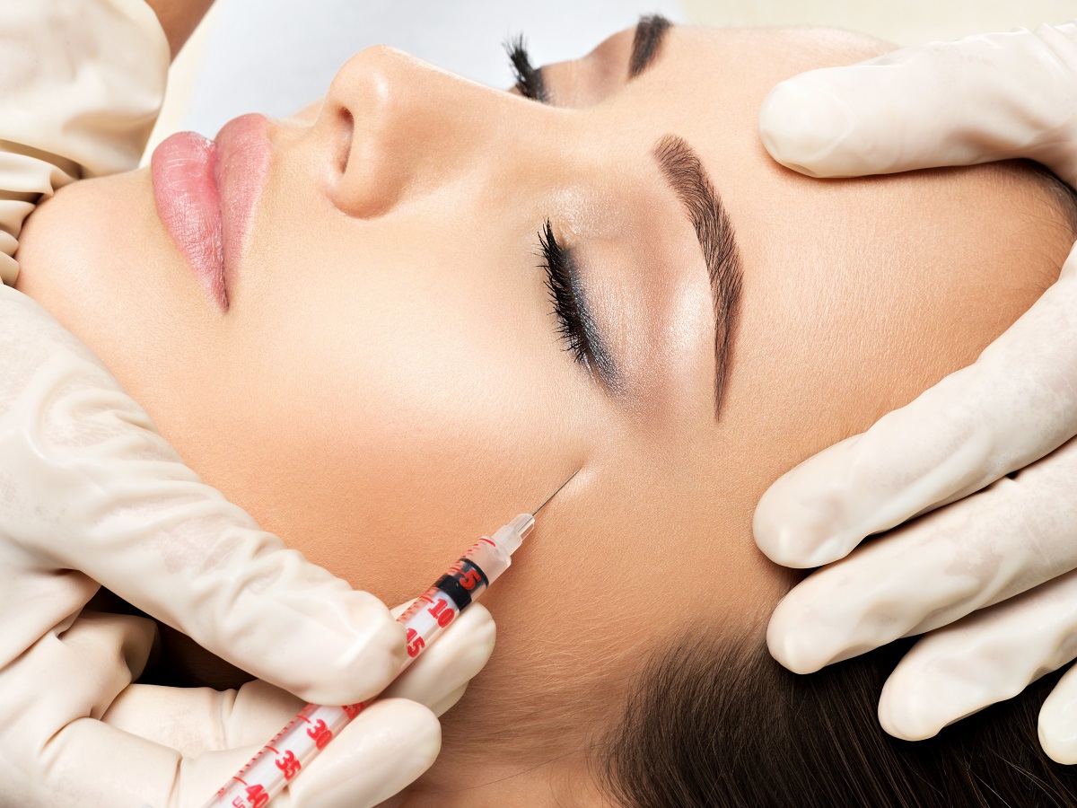 Woman getting cosmetic injection of botox near eyes, closup. Woman in beauty salon. plastic surgery clinic.